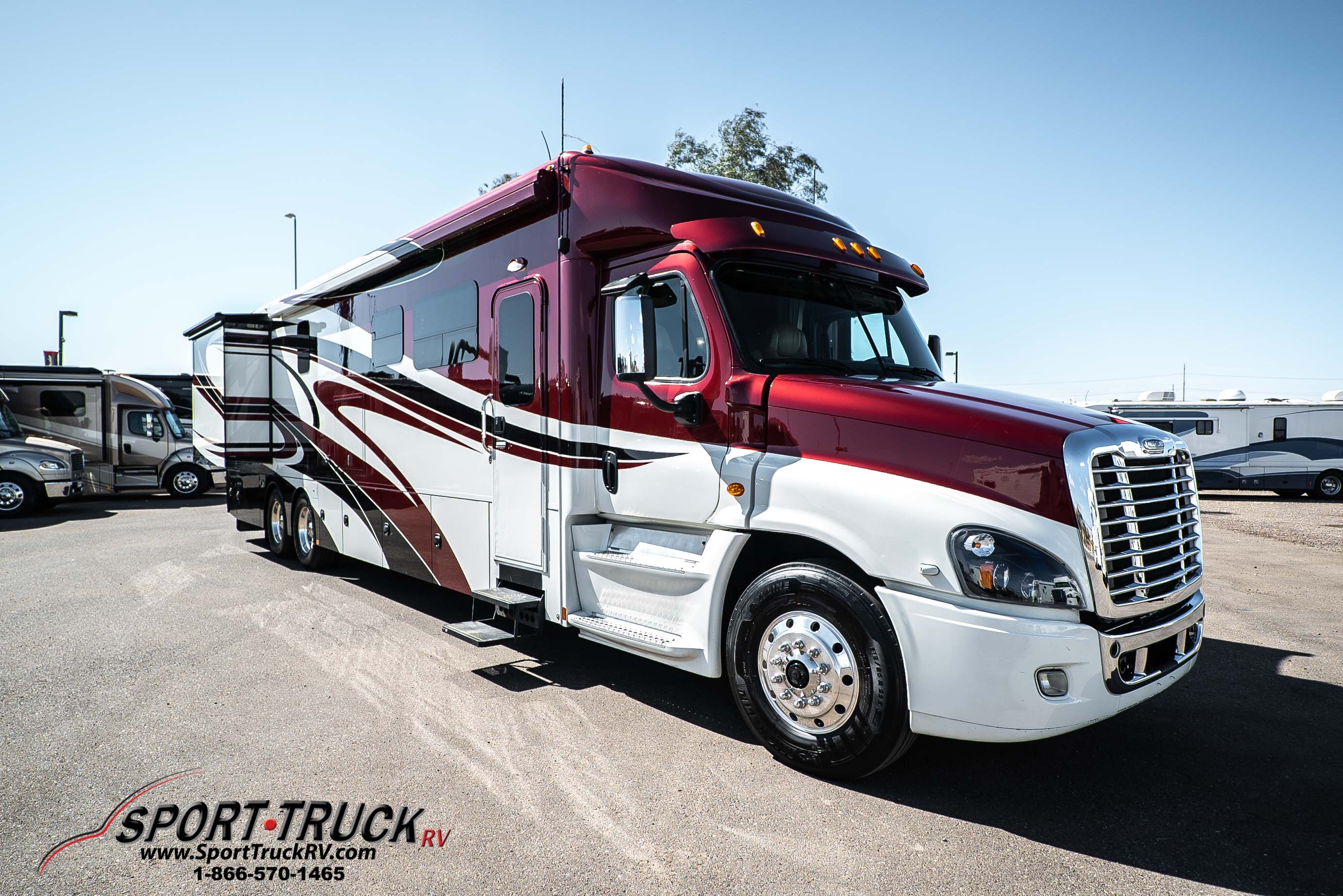 Red and white used Renegade RV parked in SportTruck RV's lot
